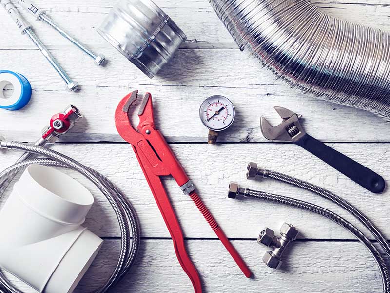 plumbing tools and accessories on wooden table. top view